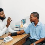 A medical professional consults with a patient during a blood pressure checkup in Lagos, Nigeria.